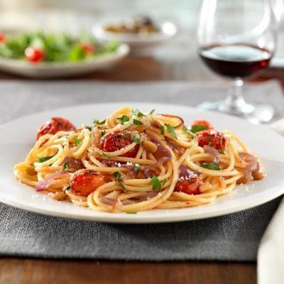 espaguete sem glúten barilla® com cebolas vermelhas caramelizadas e tomates cereja inteiros, pinhões e queijo pecorino