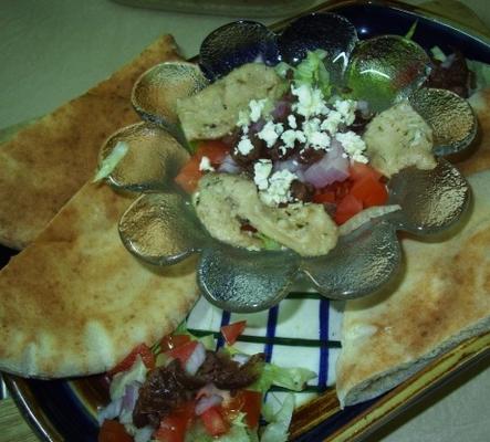 frango grelhado, de estilo grego, com salada e pão pita quente para