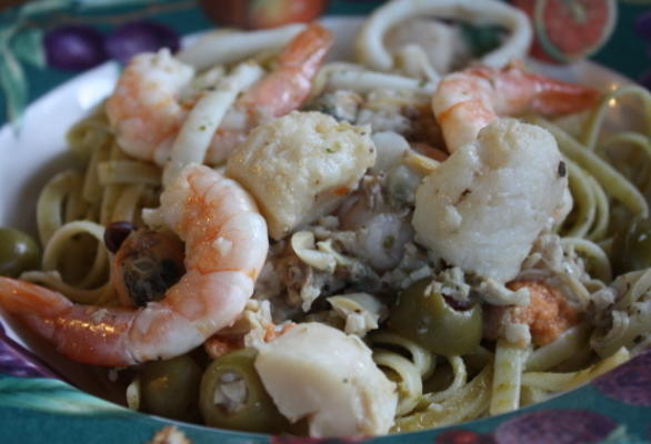 O linguine e a salsa di pesto com frutta del mare