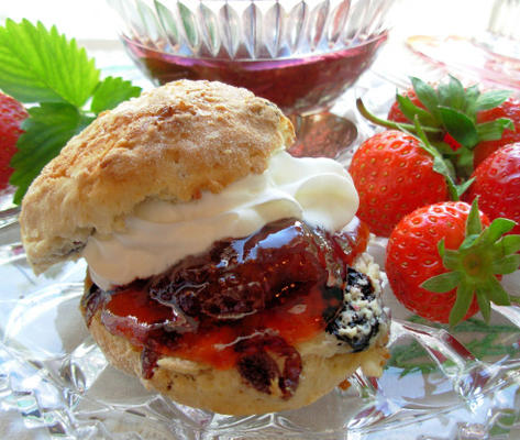 bolinhos ingleses com bagas e creme misturados do verão